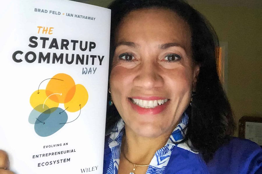 Miriam holding book - The Startup Community Way